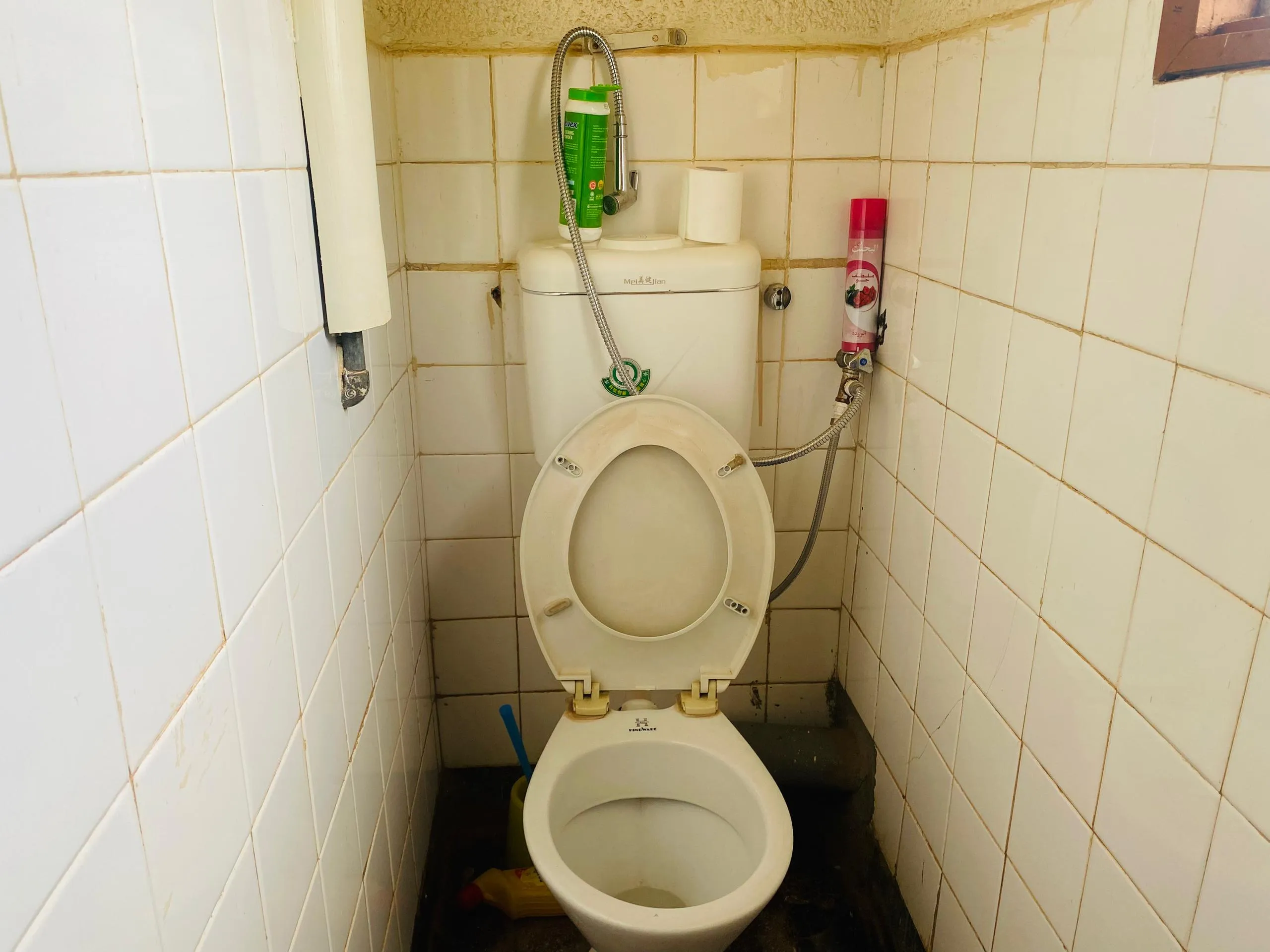 Toilet cubicle in poor condition before plumbing maintenance and renovation